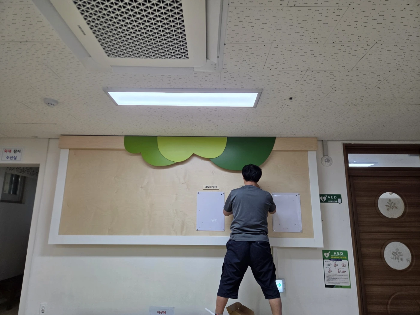 실내 벽면 게시판을 설치하고 정리하는 작업 모습